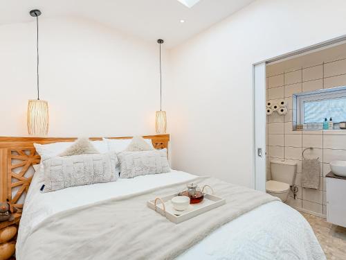 biała sypialnia z dużym łóżkiem z tacą w obiekcie The Hideaway w mieście Great Meols