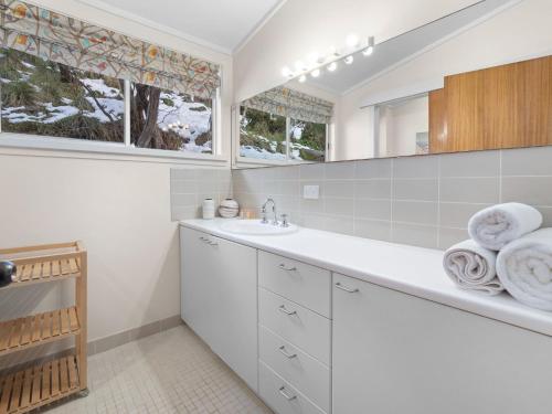 a white bathroom with a sink and a window at Tombarra 4B in Thredbo