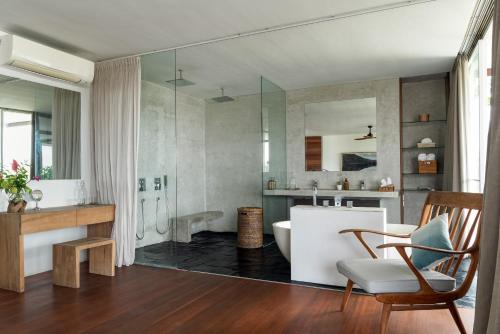 a bathroom with a white tub and a sink at Villa Nedine in Canggu