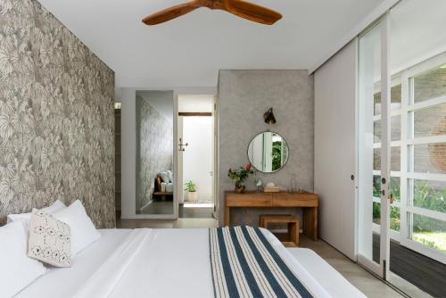 a bedroom with a large bed and a mirror at Villa Nedine in Canggu