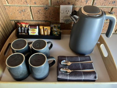 a group of coffee mugs sitting on a counter at Alexandra Motor Inn - Victoria Aus in Alexandra