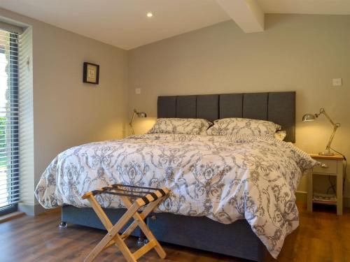 a bedroom with a large bed and a wooden stool at The Stables - Uk13658 in Middleton