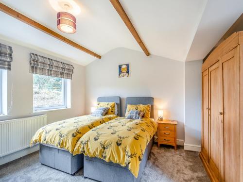 sypialnia z łóżkiem z żółtą narzutą w obiekcie The Cottage At Breeze Hill w mieście Storth