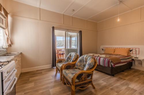 a bedroom with a bed and two chairs at Walpole Rest Point Caravan Park in Walpole