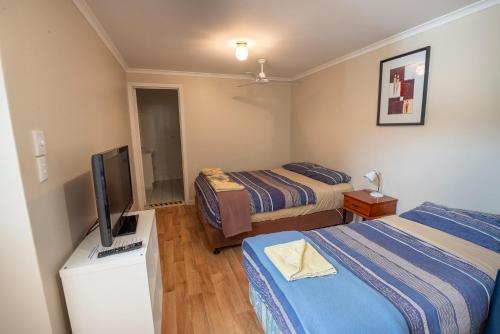 a hotel room with two beds and a television at Walpole Rest Point Caravan Park in Walpole