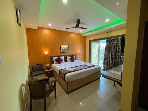 a bedroom with a bed and a desk and a window at Hotel Sagar Kanya INN in Puri