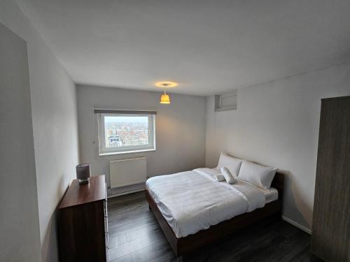 um pequeno quarto com uma cama e uma janela em Apartment Near Towerbridge em Londres
