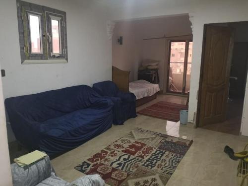een woonkamer met een blauwe bank en een slaapkamer bij Cozy 15 min to airport 10 to public transport in Caïro