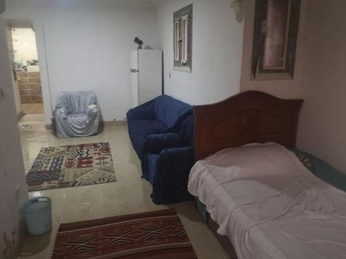 een slaapkamer met een bed, een bank en een koelkast bij Cozy 15 min to airport 10 to public transport in Caïro