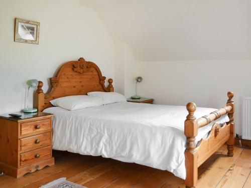 een slaapkamer met een groot bed en een houten dressoir bij Clover Cottage - Uk46269 in Tetney