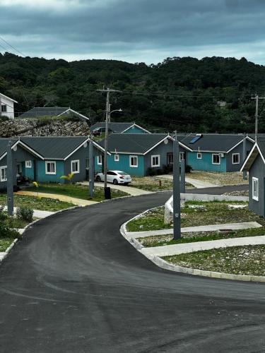 Une route sinueuse dans un quartier résidentiel avec des maisons dans l'établissement Sky View Villas @ Edmund Ridge Estate, à Montego Bay
