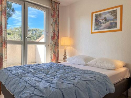 une chambre avec un grand lit avec une fenêtre dans l'établissement Duplex avec piscine, 3 pièces cabine, 6 couchages, terrasses et parking proche plage - Le Lavandou - FR-1-251-536, au Lavandou