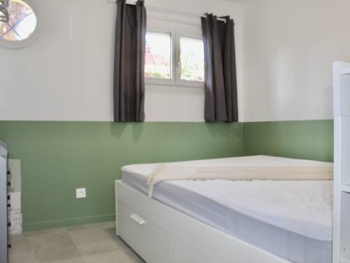 - une chambre dotée d'un lit avec un mur vert dans l'établissement Charmant 2P Climatisé, Terrasse et Parking, 4 Couchages - Villeneuve-Loubet - FR-1-252A-115, à Villeneuve-Loubet