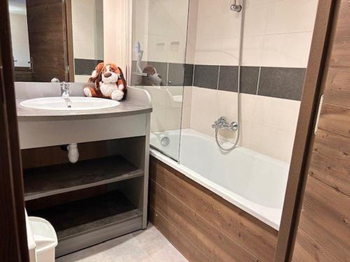 a bathroom with a sink and a tub with a stuffed animal at Appartement Risoul, 2 pièces, 4 personnes - FR-1-330-569 in Risoul
