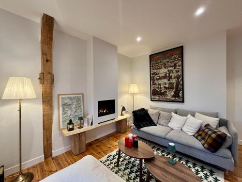 un salon avec un canapé et une télévision dans l'établissement Charmant T3 au centre du Mont-Dore avec Wifi et équipements modernes - FR-1-608-265, à Le Mont-Dore
