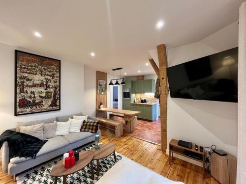 un salon avec un canapé et une table dans l'établissement Charmant T3 au centre du Mont-Dore avec Wifi et équipements modernes - FR-1-608-265, à Le Mont-Dore