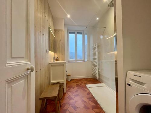 La salle de bains est pourvue d'un lave-linge et d'une fenêtre. dans l'établissement Charmant T3 au centre du Mont-Dore avec Wifi et équipements modernes - FR-1-608-265, à Le Mont-Dore