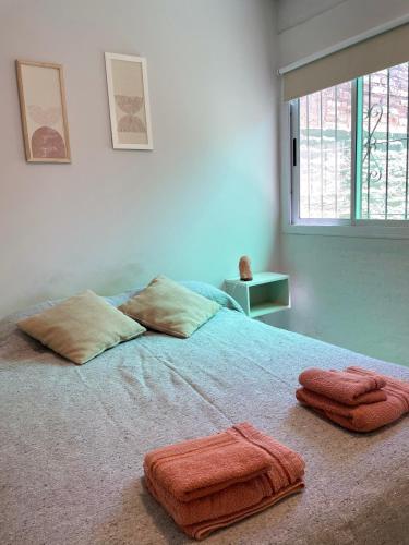 a bedroom with two towels on a bed with a window at Departamento en San Juan in San Juan