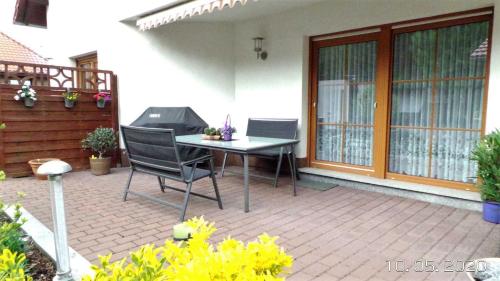a patio with a table and chairs on a patio at Ferienwohnung Reulecke in Blankenburg