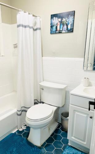 a white bathroom with a toilet and a sink at Oxon Hill Cosy Middle Unit 2 bedroom and 1bath near Gaylord in Oxon Hill