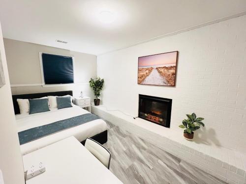 a white bedroom with a bed and a fireplace at Oxon Hill Cosy Middle Unit 2 bedroom and 1bath near Gaylord in Oxon Hill
