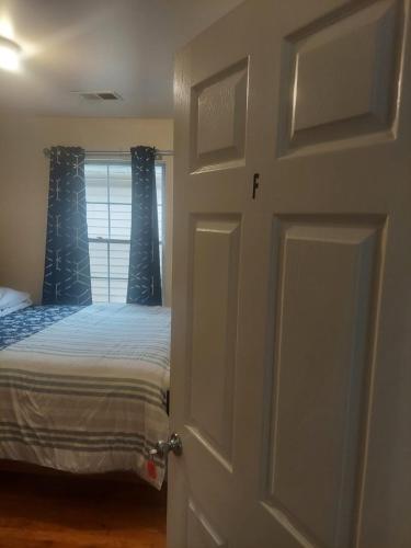a bedroom with a bed and a door with a window at Crystal Room 1 Guest House near 12mins to EWR airport / Prudential / NJIT / Penn station in Newark