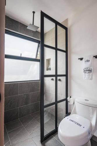 a bathroom with a toilet and a walk in shower at La Fábrica #6 Can Bonastre in Valle de Bravo