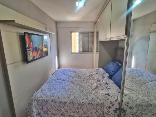 ein kleines Schlafzimmer mit einem Bett und einem TV in der Unterkunft Apto 8° andar, 4 min do shopping. in São Paulo