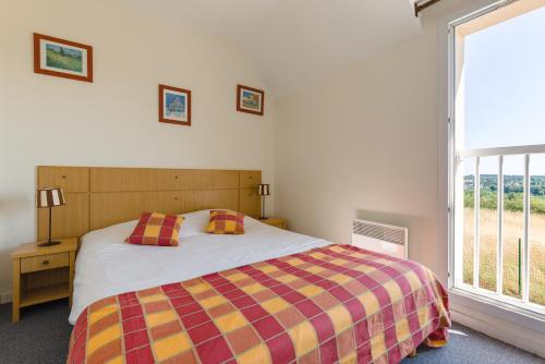 a bedroom with a bed and a large window at Lagrange Vacances Les Jardins Renaissance in Azay-le-Rideau