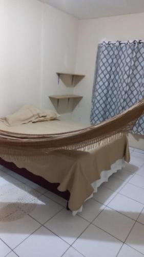 łóżko siedzące na piętrze obok krzesła w obiekcie Apto Aconchegante em Fortaleza-CE w mieście Fortaleza