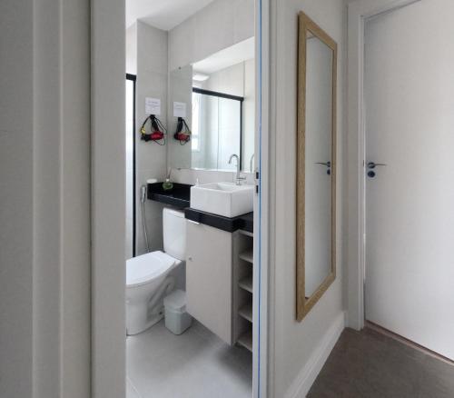 a bathroom with a toilet and a sink and a mirror at Apto Confortável prox ao Allianz in Sao Paulo