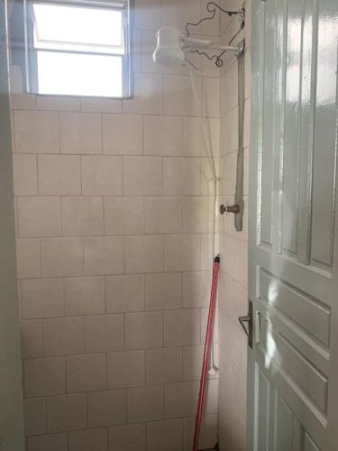 een badkamer met een deur en een rode dweil bij Casa bem localizada Cidreira in Cidreira