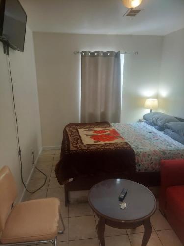 a room with a bed and a table and a couch at Crystal Room 1 Guest House near 12mins to EWR airport / Prudential / NJIT / Penn station in Newark