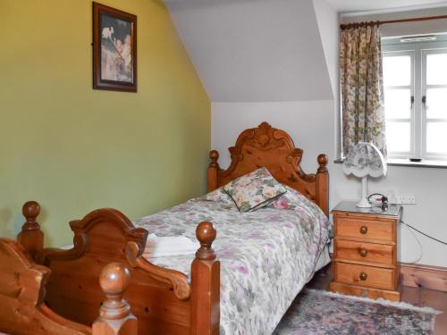 a bedroom with a wooden bed and a dresser at Buttermilk Cottage - Uk46270 in Tetney