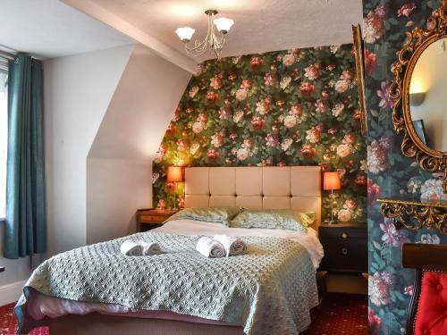 斯沃尼奇的住宿－Swanage Beach House，一间卧室配有一张大床和毛巾