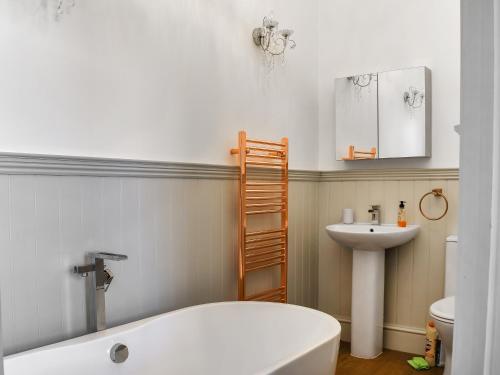 斯沃尼奇的住宿－Swanage Beach House，浴室配有白色浴缸和水槽
