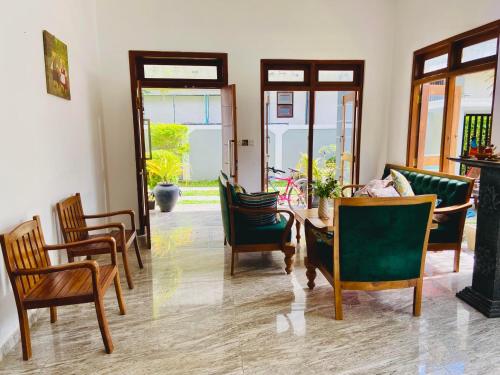 a living room with chairs and a table at Erin Orr Villa in Wadduwa