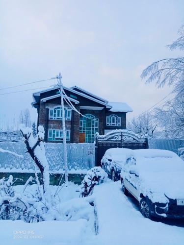 a house with two cars covered in snow at Sunset View Gulmarg in Gulmarg