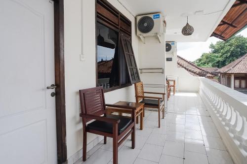 a row of chairs sitting on a house balcony at City Garden Bali Dwipa Hotel in Kuta