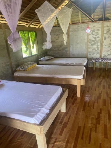 2 camas en una habitación con suelo de madera en Towoc Restaurant and Bungalows, en Hog Harbour