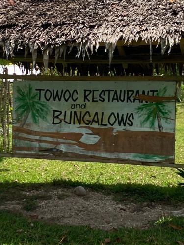 un cartel que diga "Dos restaurantes y bunaturdays" en Towoc Restaurant and Bungalows, en Hog Harbour