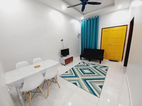 a dining room with a table and chairs and a yellow door at Aufa House in Padang Rengas