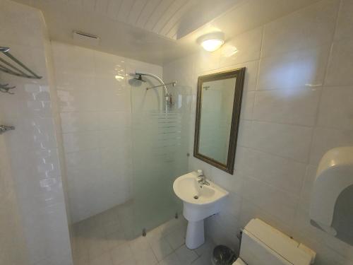 a white bathroom with a sink and a mirror at Hotel Oceanview in Incheon