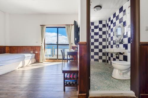 a bedroom with a bed and a toilet and a window at Water Swing B&B in Renai