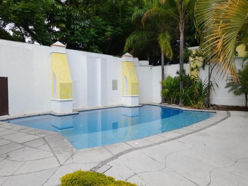 een zwembad naast een wit hek bij Chinelos Express Desayuno en cortesia in Cuernavaca