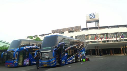 three double decker buses parked in front of a building at Buritel Hotel in Buriram