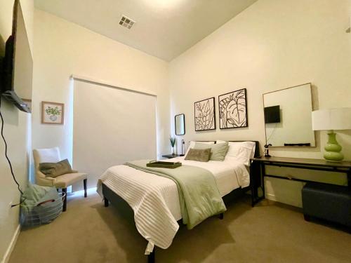a bedroom with a bed and a desk with a mirror at Fremont Experience with Pool/spa in Las Vegas