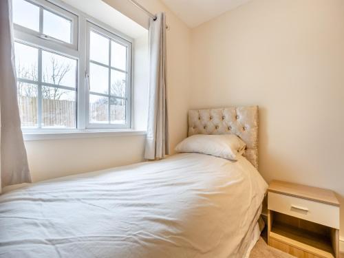 Schlafzimmer mit einem Bett und einem Fenster in der Unterkunft Lazy Acre in Holbeach