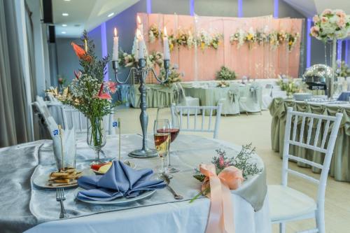 a table with glasses of wine and flowers on it at Buritel Hotel in Buriram