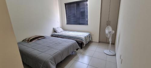 Habitación pequeña con 2 camas y ventana en Casa con alberca Mirador 126, en Querétaro